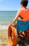 Child in a wheelchair looks at the sea