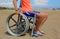 Child on the wheelchair on the sandy beach