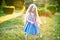 Child whirling, dancing plays on the meadow. Girl having fun with bubbles. Cute little longhair blonde girl dancing with soap