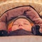 A child in winter clothes sleeps lying in a baby carriage , face close-up, age 8 months