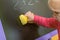 The child wipes the blackboard with a damp sponge from inscriptions and drawings. The concept of preschool education for children