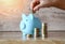 Child woman hand putting money coin into piggy bank for saving money for education study or investment , Stack coins Save money