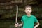 Child with wooden staff against background of rock