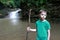 Child with wooden staff in front of Waterfall Cascade on Rufabgo stream