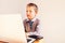 Child working with his computer in his business, concentrated typing to succeed, funny image