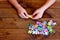 Child working on jigsaw puzzle. Child holding a puzzle in hands. Group of jigsaw puzzles on wooden table