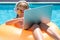 Child working on laptop from the swimming pool. Outdoor summer business.