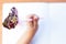 A child writes in an empty notebook on a wooden desk background. Back to school concept. Top view