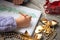 Child writes letter to Santa and draw a Christmas tree. Golden Christmas beads and gold ribbon bows on wooden