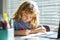 Child writing at school. Preteen schoolboy doing her homework at home. Child study. Education and learning for kids