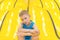 Child on yellow playground trampoline. Kids jump in inflatable bounce castle on kindergarten birthday party. Activity and play cen