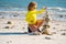 Child with zen stones on sea beach, meditation, spa and harmony. Calm balance concept. Kids play on the beach. Keep calm