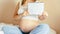 Childbirth checklist pregnant woman. Beautiful pregnancy woman writing check list. Happy pregnant lady holding notepad