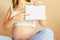 Childbirth checklist pregnant woman. Beautiful pregnancy woman writing check list. Happy pregnant lady holding notepad