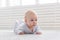 Childhood, babyhood and people concept - little baby boy or girl crawling on floor at home