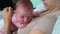 Childhood and beginnings concept. Closeup indoor portrait of sleepy infant caucasian baby lying on mother's chest