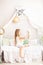 Childhood concept. Child playing in bed in a white bedroom. Children`s room and interior design. Little girl in pajamas at home. T