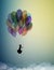 Childhood dream concept, girl silhouette flying on the air baloon and flying up to the sky with flock of flying birds