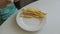 Childhood and eating concept - little girl enjoying a burger and french fries on the table enjoying unhealthy food