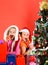 Childhood and happiness concept. Kids in Santa hats with gifts