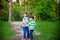 Childhood, hiking, family, friendship and people concept - two happy kids walking along forest path