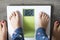 Childhood obesity high risk for health problems with childâ€™s feet on weight scale under the supervision of his mother