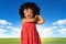 Childhood and people concept-cheerful african american little girl over landscape background