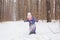 Childhood and people concept - child girl walking in the winter outdoors and throwing the snow up