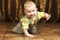 Childhood. Portrait of crawling baby boy on the bed curiously looking behind the camera