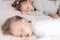 Childhood, sleep, relaxation, family, lifestyle concept - two young children 2 and 3 years old dressed in white and