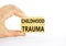 Childhood trauma symbol. Concept words Childhood trauma on beautiful wooden blocks. Beautiful white background. Psychologist hand