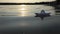 A childish paper boat swims in a lake water at sunset in slo-mo