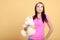 Childish young woman infantile girl in pink hugging teddy bear toy