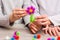 Children add from the details of colored sticky mosaics into a flower on the table. Leisure of the child in confinement.