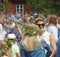 Children and adults wearing traditional costume and flowers in t