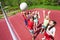 Children with arms up to ball play volleyball