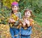 Children in autumn forest. Play with fallen down leaf