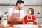 Children, baking, family concept. Cheerful brunet male wears apron and kneads dough, happy girl holds rolling pin, ready