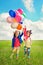 Children with balloons walking on spring field