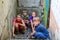 Children in the basement, three boys and a girl near the iron door are hiding on the steps from the outside world. Post-production