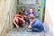 Children in the basement, three boys and a girl near the iron door are hiding on the steps from the outside world. Post-production