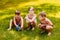 Children in bathing suits sit on green grass in summer