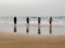 Children at beach with Reflections in Wet Sand