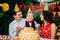 Children birthday theme. family of three Caucasian people sitting in backyard of the house at a festive decorated table in funny h