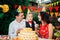 Children birthday theme. family of three Caucasian people sitting in backyard of the house at a festive decorated table in funny h