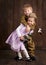 Children boy are dressed as soldier in retro military uniforms and girl in pink dress