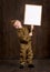 Children boy are dressed as soldier in retro military uniforms. He holds blank poster for veterans portrait.