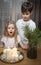 Children - a boy and a girl blow out Christmas candles at home in the evening