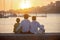 Children, boys, brothers, enjoying sunset over river with their pet maltese dog and mom, boats, sun, river