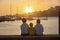 Children, boys, brothers, enjoying sunset over river with their pet maltese dog and mom, boats, sun, river